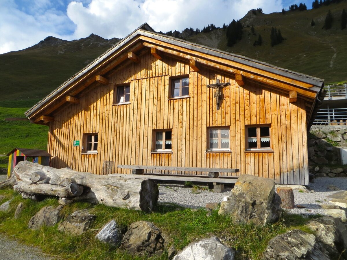 Die neue Bio-Alphütte aus heimischem Holz auf der Alpe Fatnella vor den Gipfeln des Großen Walsertals