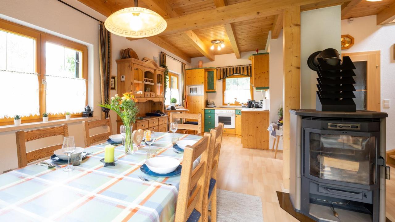 Essbereich mit Kachelofen und offener Küche im Ferienhaus