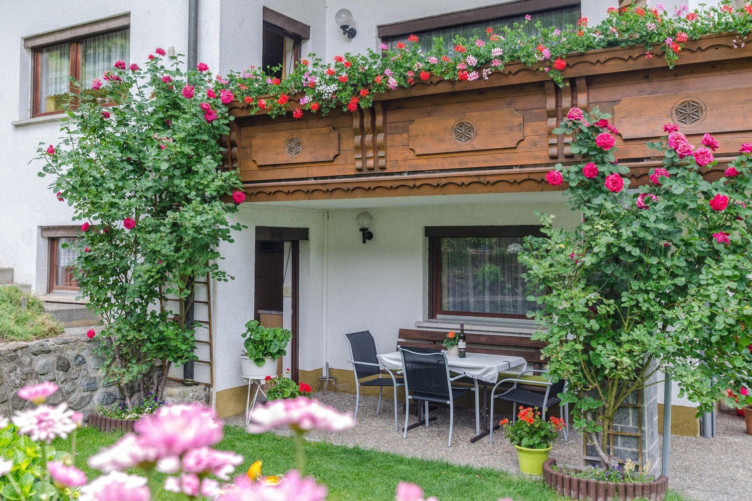 Sitzplatz im Garten des Haus Waldheimat unter dem Geranienbalkon