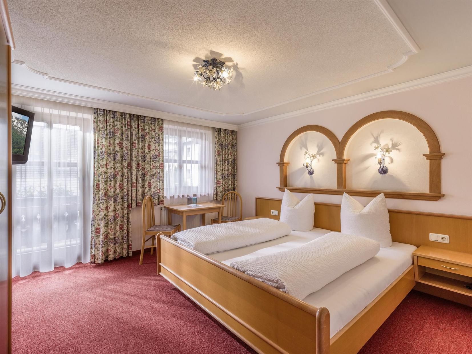 Doppelzimmer im Haus Sonnblick mit gemütlicher Einrichtung und Balkonzugang