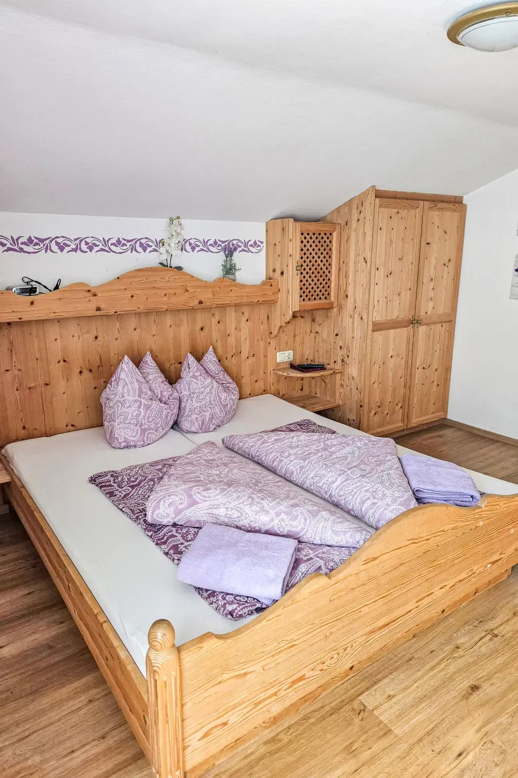 Schlafzimmer mit Doppelbett aus Holz im Haus Alpina