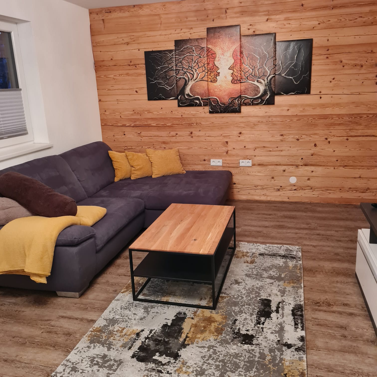 Wohnzimmer mit Zirbenholzwand im Appartement Leon
