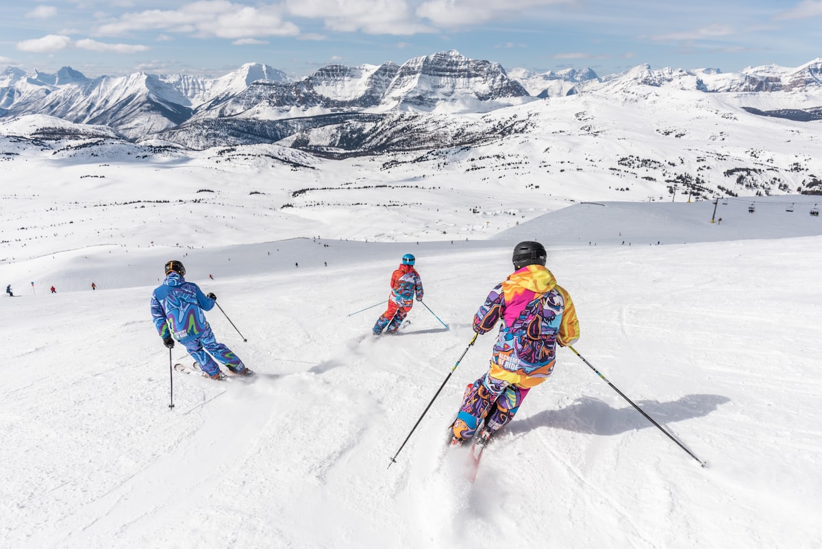 Skifahrer auf einer breiten Piste über dem Tal