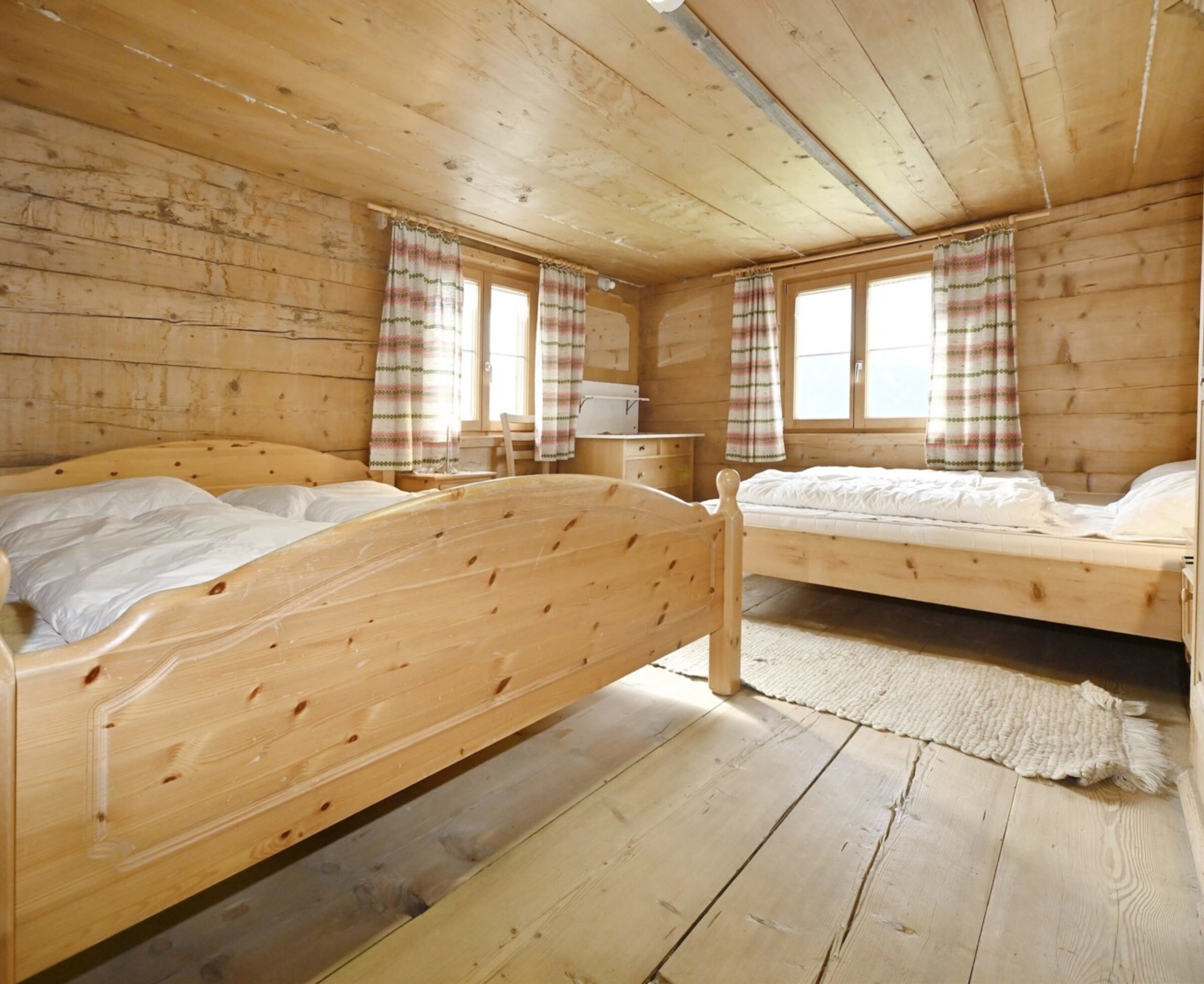 Helles Schlafzimmer in der Biohütte aus Zirbenholz mit zwei Betten
