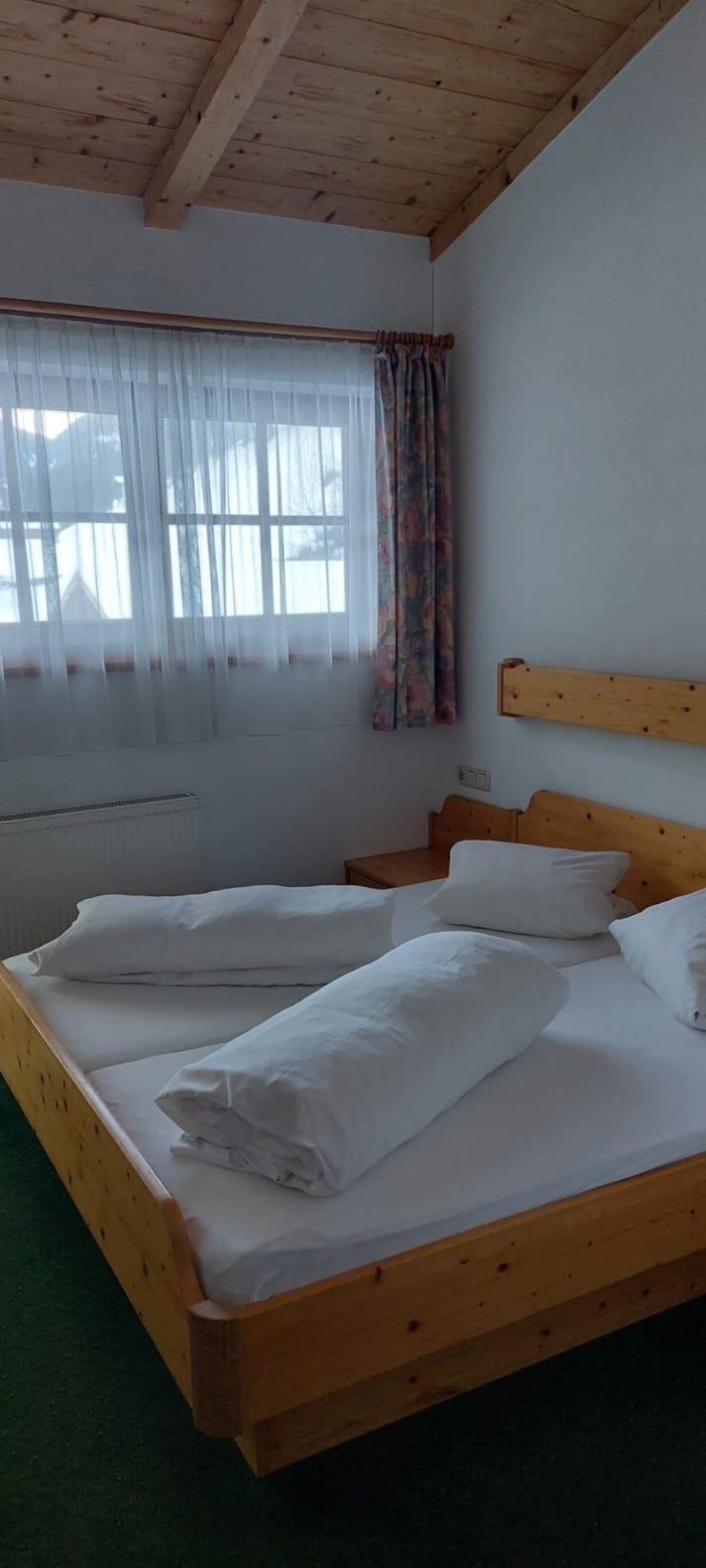 Schlafzimmer mit Holzbett in der Ferienwohnung im 2. Stock des Gasthof Sandwirt
